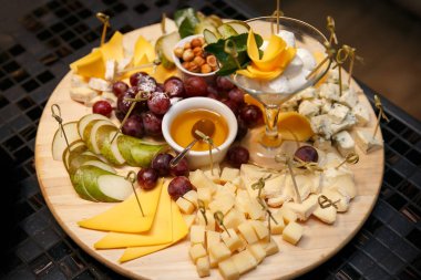 Üzüm, reçel ve bir ahşap tahta üzerinde fındık ile peynir tabakları servis. Üstten Görünüm