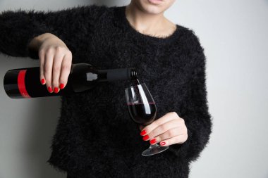 bir genç kadın yağan kırmızı şarap eline bir şişe cam, yakın çekim