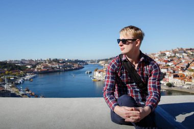 Bir sarışın bir Avrupa şehri ele oturuyor.