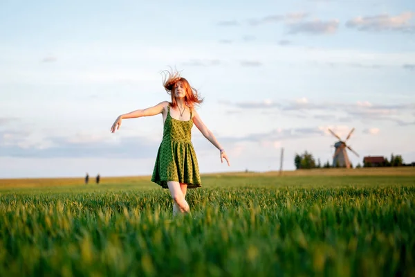 Happy blonde girl, dancing in a field full of yellow flowers. background of summertime and blue skies. — Stock Photo, Image