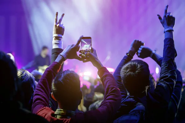 Mão com um smartphone no concerto de música ao vivo, tirando foto do palco, ao vivo, festival de música — Fotografia de Stock