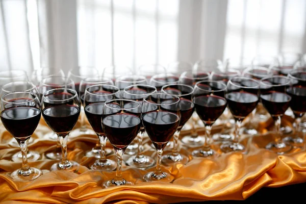 Bir tabloda bir partide kırmızı şarap gözlük. — Stok fotoğraf
