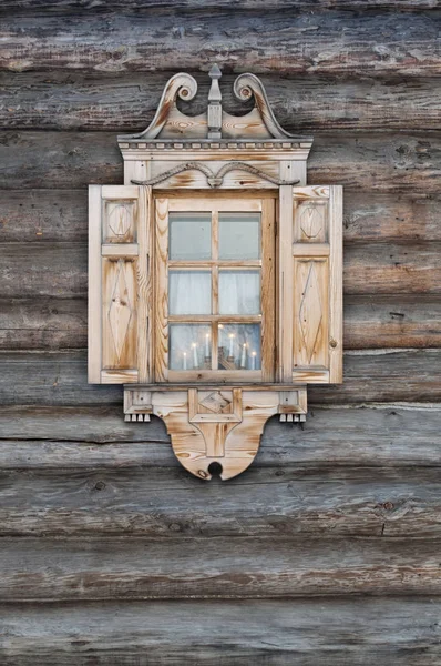 Ventana con arquitrabes tallados en una choza de madera . —  Fotos de Stock