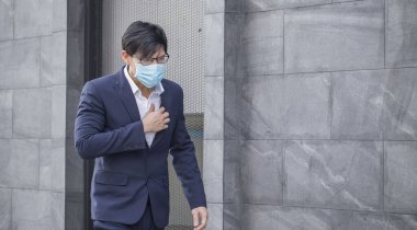 Asian businessman wears a suit with coughing, sneezing and wearing a mask to prevent the outbreak of the virus covid19 ..Concepts health and prevention of serious laxative diseases. clipart