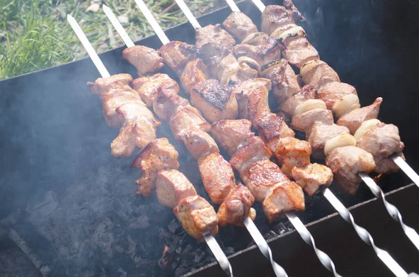 Traditional skewers on skewers and barbecue. Springtime outdoor recreation. Grilled meat.