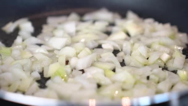 料理するためにオリーブオイルでフライパンで玉ねぎを炒める女の子 — ストック動画