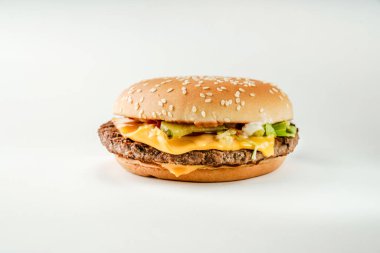  Kızarmış biftek ve peynirli hamburger, beyaz arka planda susam tohumlu bir çörek.