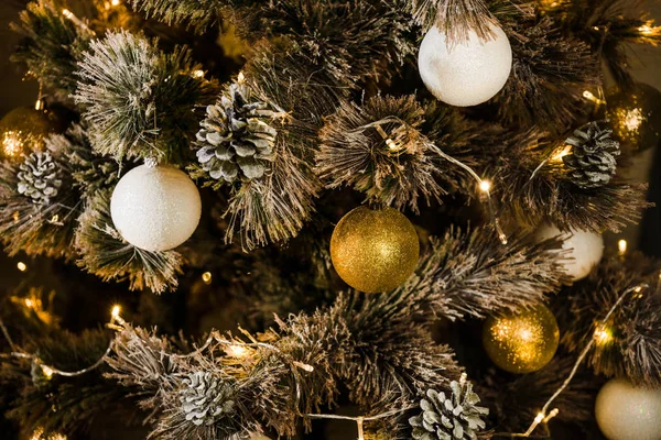 Christmas tree decorated with white and gold balls in the lights