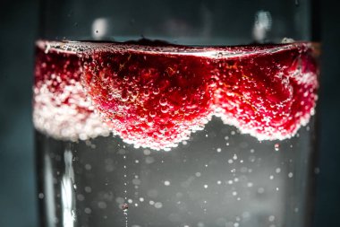 Ahududulu bir kadeh şampanya. Bardakta kabarcıklar