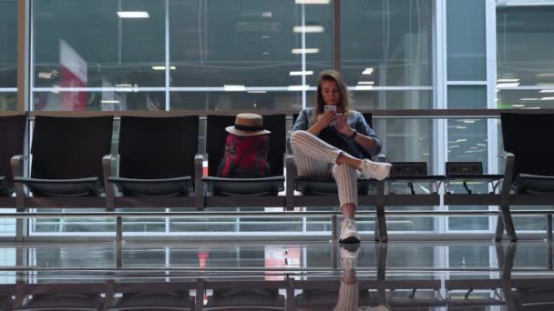 Rapariga Está Espera Embarcar Aeroporto Uma Menina Notícias Telefone — Vídeo de Stock