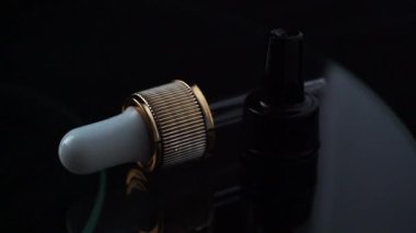 Kozmetik. Bir şeyleri saklamak için bir kavanoz. Pipette. Siyah arka planda kozmetik hazırlıkları. farmakoloji