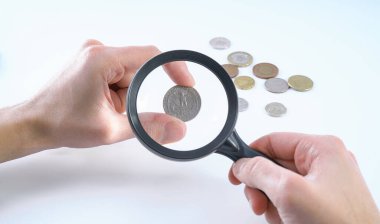  Bozuk para koleksiyoncusu. Bir adam sikkeleri büyüteçle inceler. Bozuk Para Yetkilendirmesi.              