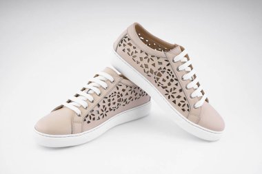 Moda dergisinin kapağı için beyaz arka planda sıradan beyaz kadın yaz ayakkabıları.           