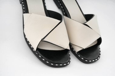 Moda dergisinin kapağı için beyaz arka planda sıradan beyaz kadın yaz ayakkabıları.           