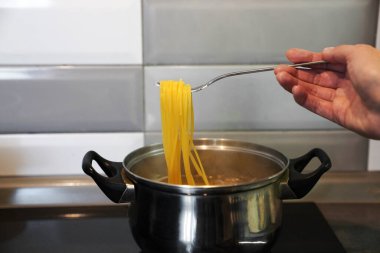   İtalyan spagettisi. Kız spagetti pişiriyor. Ev yapımı yemek. evde yemek pişirmek.                             