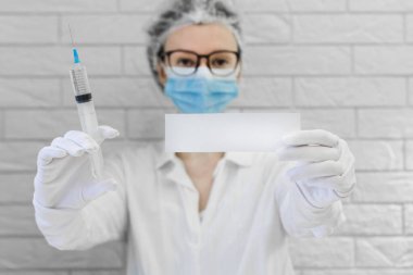 Doktor bir enjeksiyon yapmak üzere. Grip aşısı. Covid-19. Anestezi uzmanı ameliyattan önce iğne yapar.
