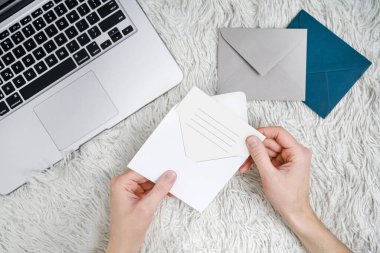 Masaüstünde zarflar olan kartpostallar. Karanlık bir masada dizüstü bilgisayarlı mektuplar.