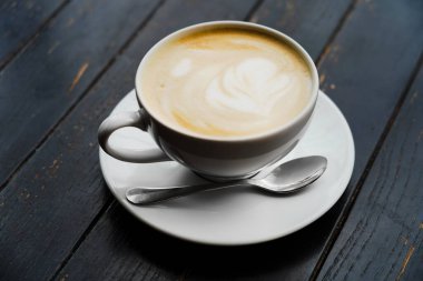 Masadaki bir kafede kapuçino. Sabah kahvesi ve gazete ayini..