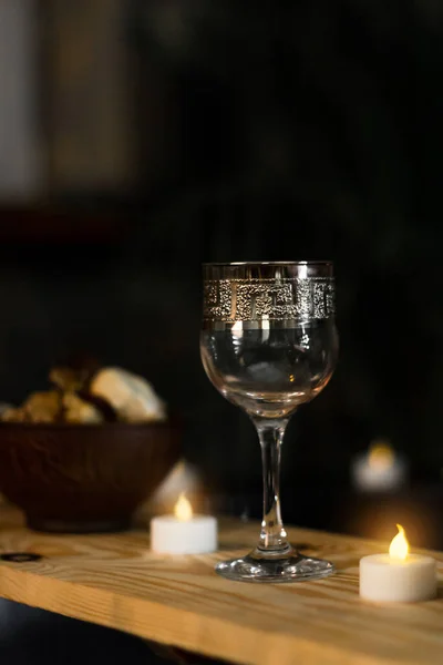 A relaxing evening with candles, wine and aromas. Glass goblet on the table. Rose petals. Romantic evening