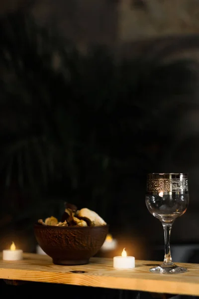 A relaxing evening with candles, wine and aromas. Glass goblet on the table. Rose petals. Romantic evening