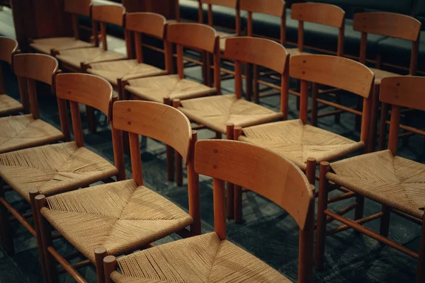 empty wooden chairs in a row in a church