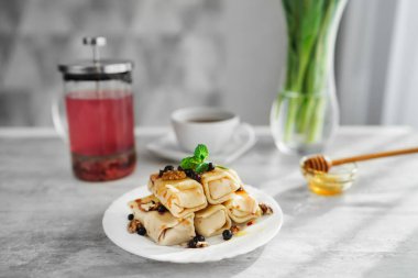 Krep ve çayın olduğu bir masada waffle ızgarası. panini presi
