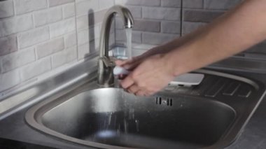 Kadın ellerini evde yıkıyor. Koronavirüs ve bakterilerden kurtulmak için ellerinizi nasıl yıkayacağınızı.