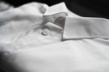 Bir ütü masasında düzgünce katlanmış çok renkli gömlekler yığını