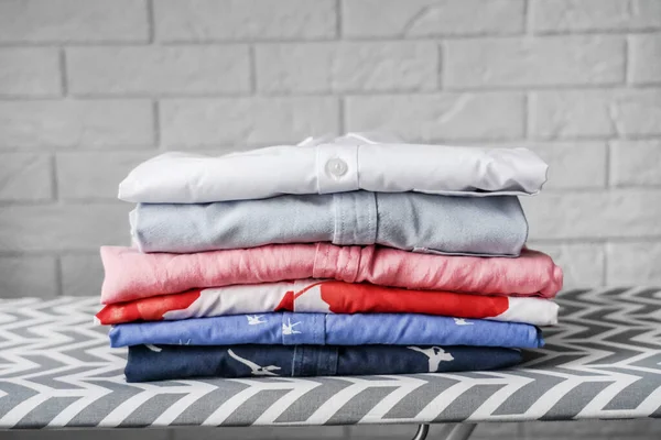 Pilha Camisas Multicoloridas Bem Dobradas Uma Tábua Engomar — Fotografia de Stock