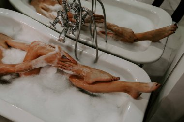 Kadın köpükle banyo yapıyor. Spa tedavileri. Zor bir günün ardından dinlenmek. Duşlu bir kadın