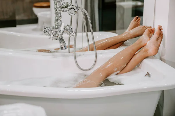 Kadın köpükle banyo yapıyor. Spa tedavileri. Zor bir günün ardından dinlenmek. Duşlu bir kadın