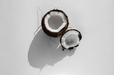 Kırık hindistan cevizi ve beyaz bir arka plan. Hindistan cevizi sütü. Üst görünüm 