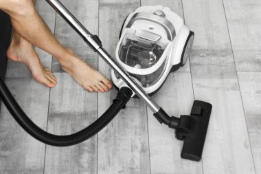 Adam evdeki yerleri süpürmekten yoruldu. Kanepede dinlenmek için oturdum. elektrikli süpürge makrosu