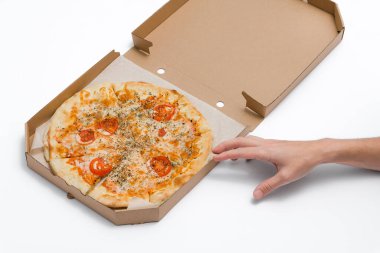 Erkek eli beyaz arka planda açık bir kutuda bir dilim margarita pizzası tutuyor. Yemek servisi. Karantina altındaki yiyecekler