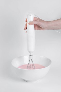   Kız bir kasede çırpıcı kremayla tatlı hazırlıyor. Ev için küçük ev aletleri. Modern mutfak iç mimarisi     