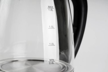  Beyaz arka planda şeffaf elektrikli su ısıtıcısı. Ev ve mutfak için küçük ev aletleri.