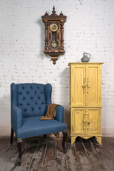 Вінтажне синє крісло, жовта шафа, маятниковий годинник і апельсин — стокове фото