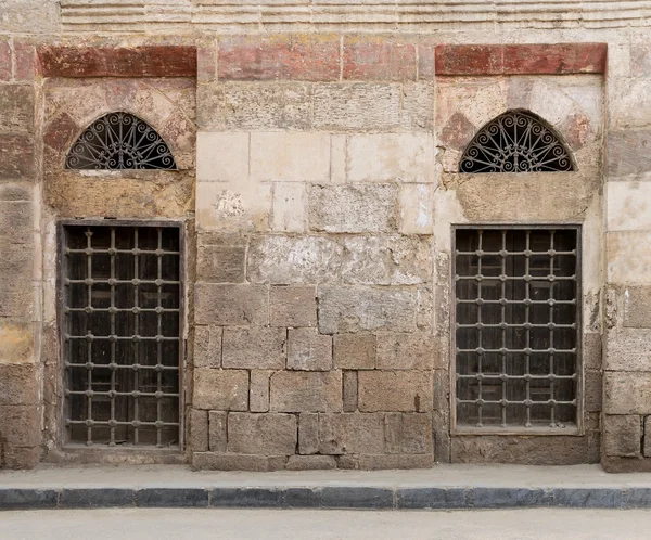 Antigua pared abandonada con dos ventanas de madera cerradas decoradas — Foto de Stock