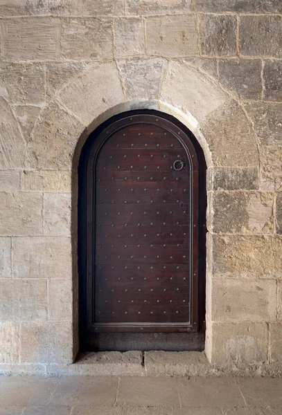 Madeira envelhecida abobadado ornamentado porta e parede de pedra — Fotografia de Stock