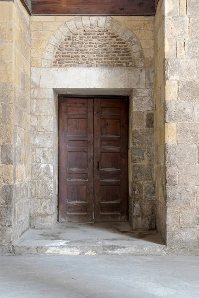 Porta ornamentada envelhecida de madeira e parede de pedra — Fotografia de Stock