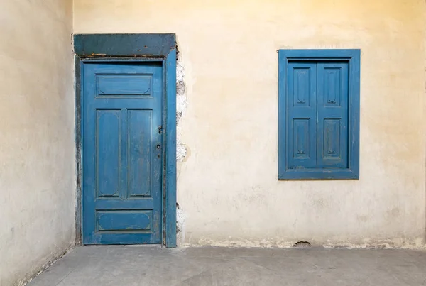 Blue wooden window and door with vintage plaster wall