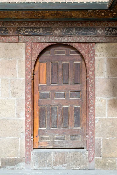 Wooden aged vaulted door and stone wall — Stock Photo, Image