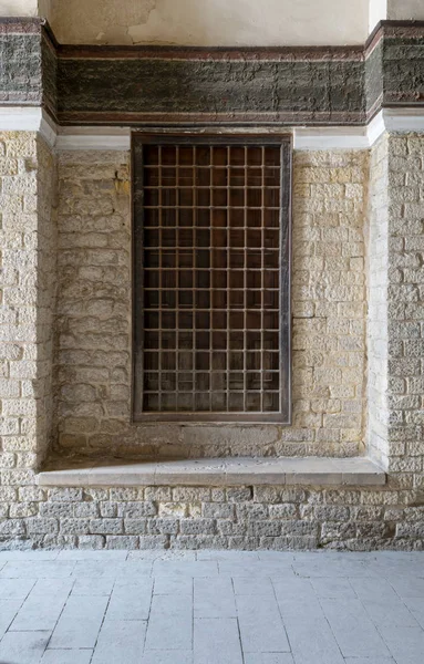 Holzfenster mit verziertem Eisengitter über Ziegelsteinmauer — Stockfoto