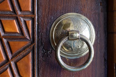 Antika bakır süslü kapı tokmağı yaşlı bir ahşap kapı üzerinde closeup