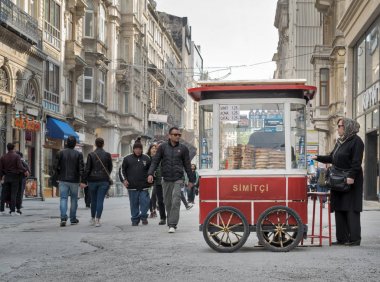 Yaşlı Türk kadın Fast food yemek Istiklal Caddesi, Istanbul, Türkiye'de geleneksel bir Türk Simit (simit) sepeti satın alma