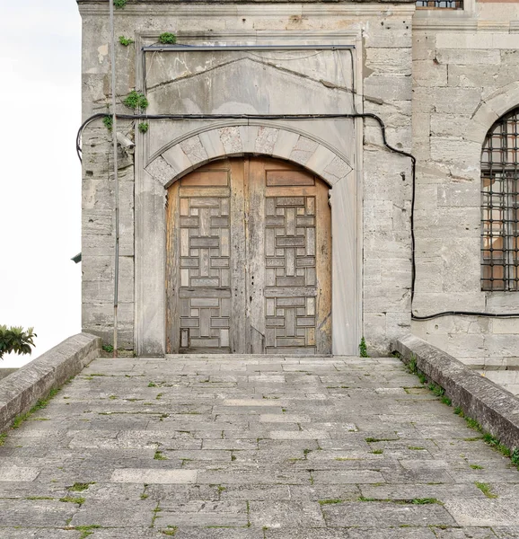 Rampa de azulejos de pedra que leva a uma porta envelhecida de madeira sobre uma parede de pedra, Mesquita Sultan Ahmed (Mesquita Azul), Istambul, Turquia — Fotografia de Stock