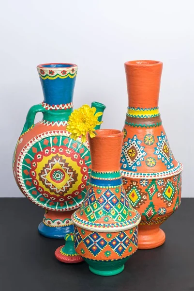 Laranja vasos de cerâmica ornamentados na mesa preta e parede branca — Fotografia de Stock