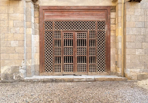 Деревянные украшенные двери над каменной кирпичной стеной — стоковое фото