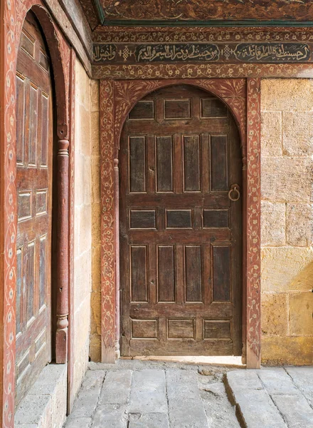 Dos puertas perpendiculares abovedadas adornadas envejecidas de madera en paredes de ladrillos de piedra — Foto de Stock