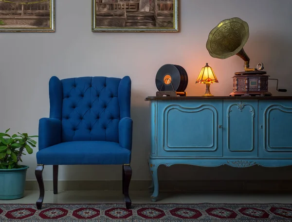 Sillón azul, aparador azul claro de madera vintage, lámpara de mesa antigua iluminada, fonógrafo antiguo (gramófono) y discos de vinilo — Foto de Stock